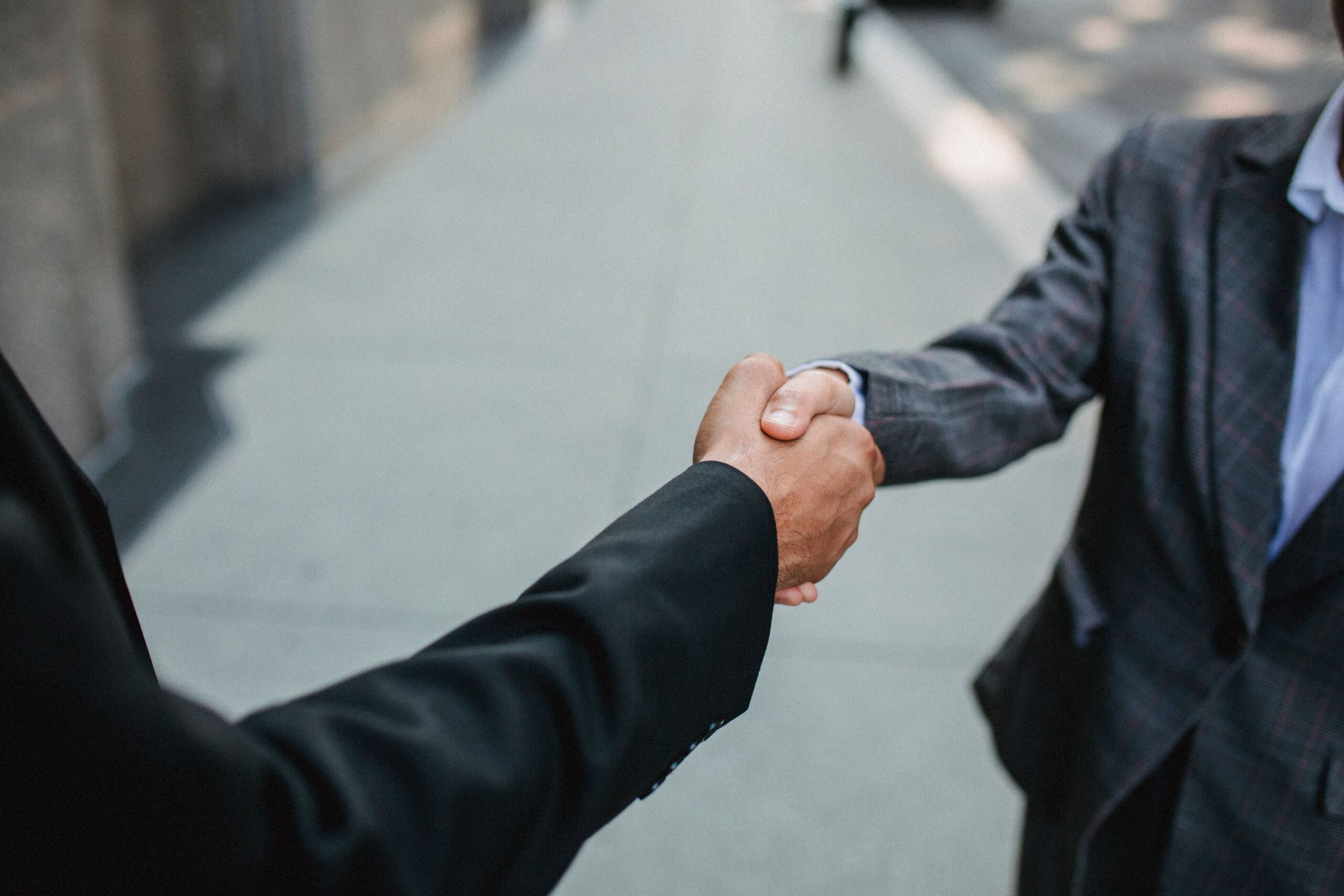 Two business owners shaking hands, the local partnership behind an earned backlink