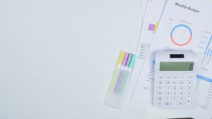 Calculator and budget planning documents on a desk, used to set a Google Ads budget